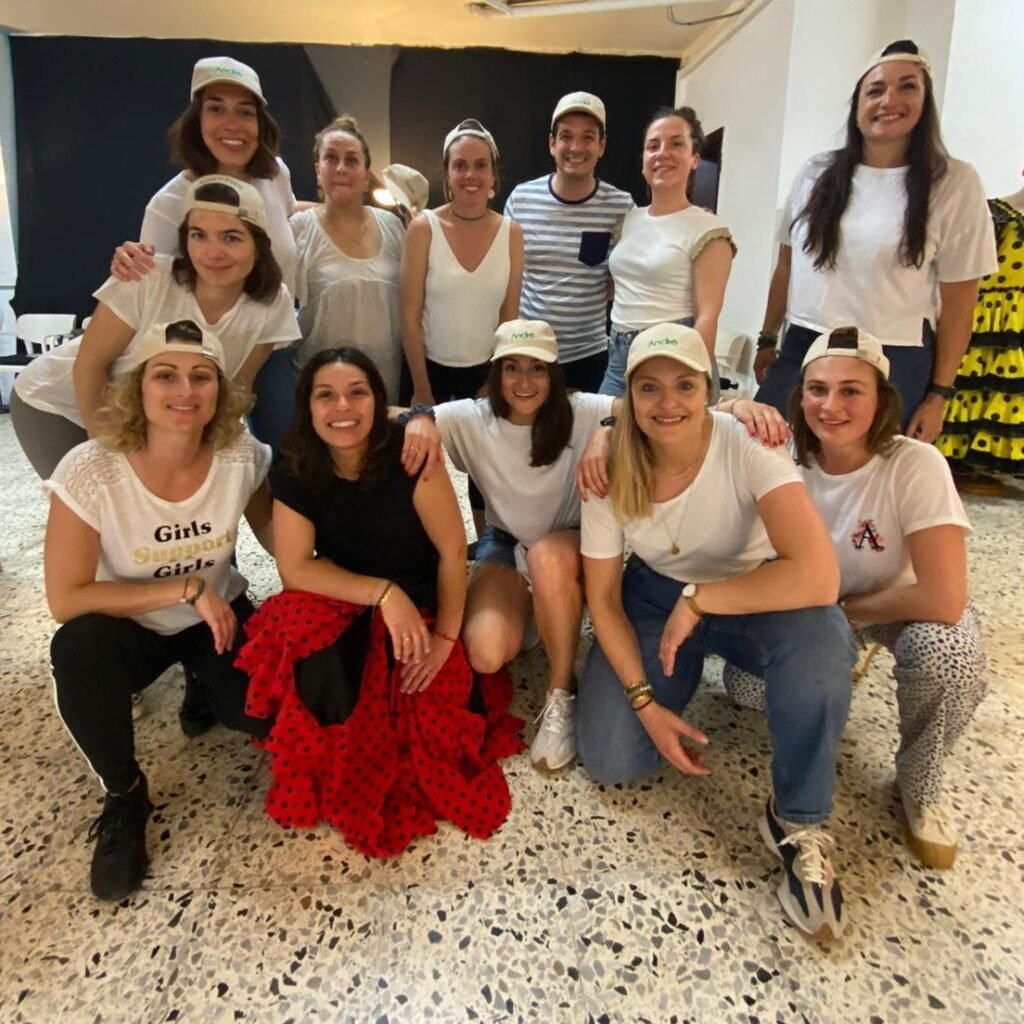 Gran grupo de empleados posando juntos después de un taller de team building con baile en Barcelona - foto de grupo sonriente en un estudio de danza