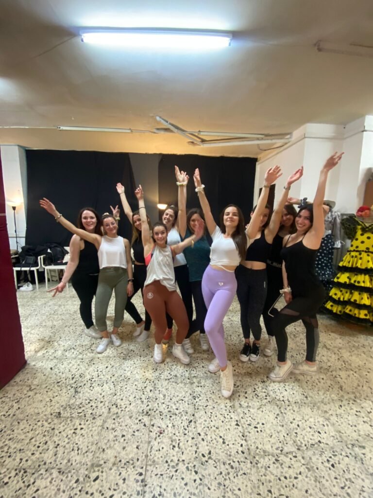 Grupo de amigas riendo y moviéndose con energía durante una clase de twerk en un estudio privado en el corazón de Barcelona