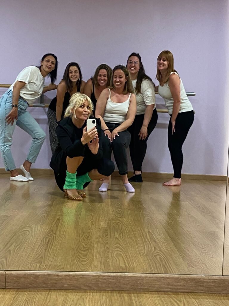 Grupo de mujeres aprendiendo los movimientos de cadera de la bachata en una clase privada de despedida de soltera en un estudio en el corazón de Barcelona