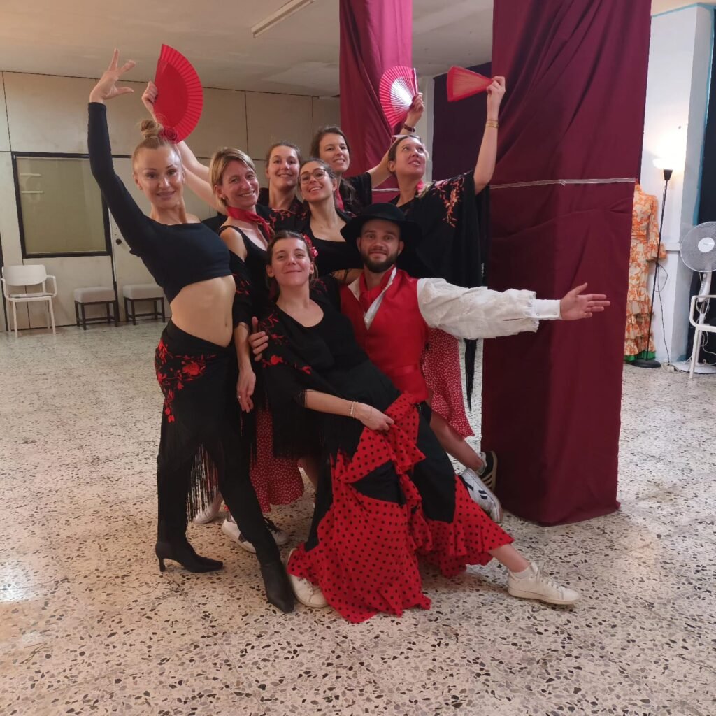 Grupo de empleados practicando flamenco durante un team building en Barcelona - participantes haciendo palmas en un estudio de danza