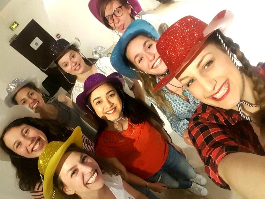 Amigas pausan en una clase de baile country en Barcelona, con sombreros de cow boy en la cabeza