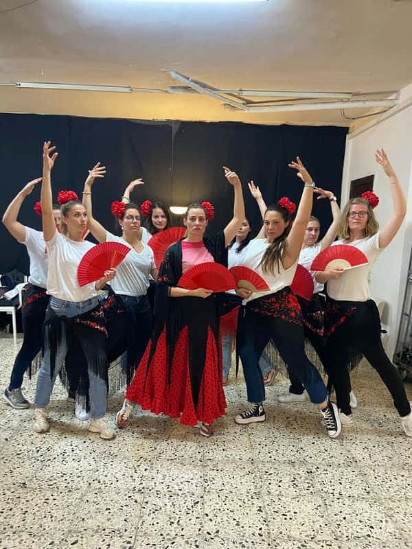 Group of friends during a private dance class in Barcelona with flamenco dress and fans