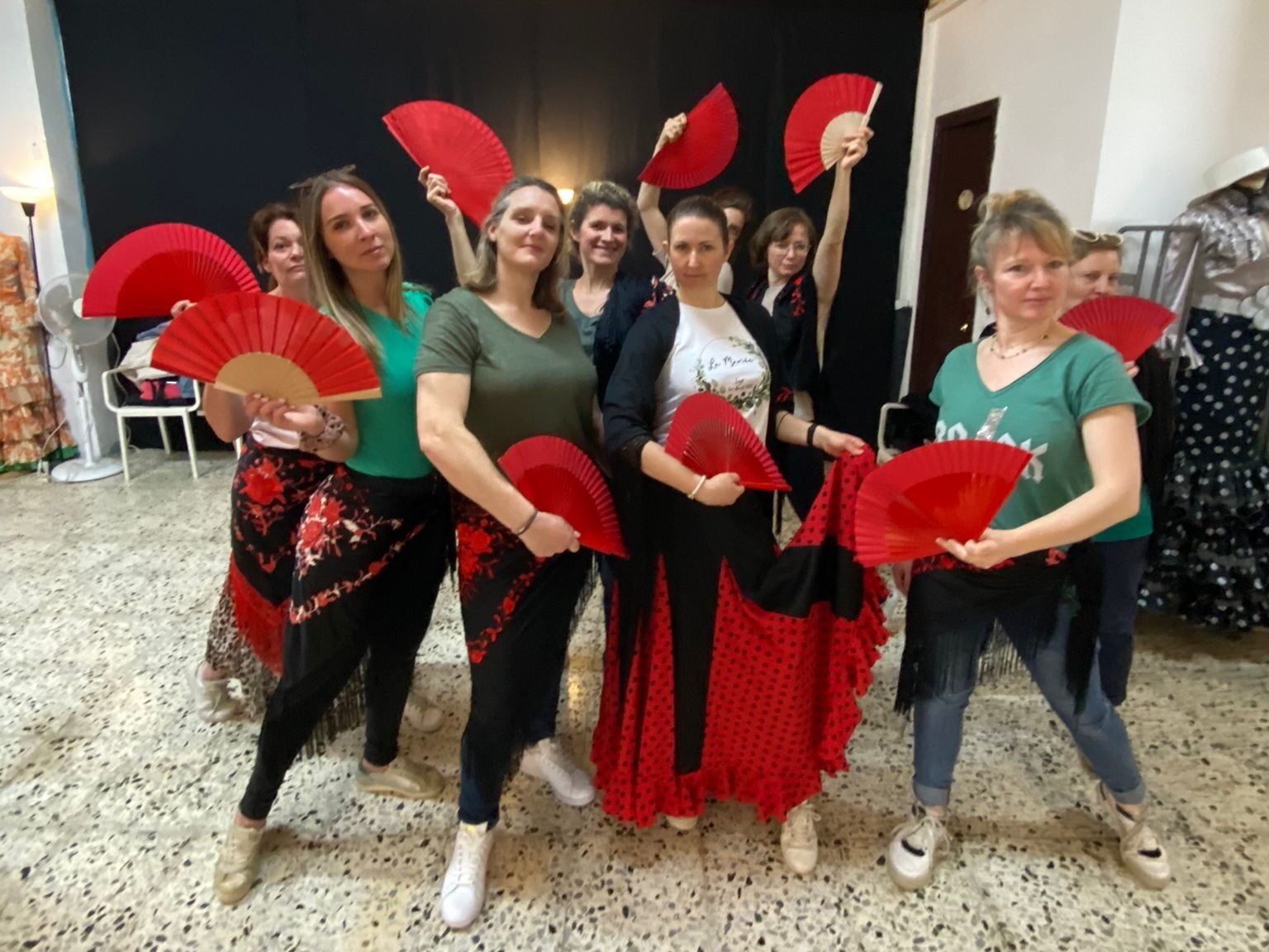 Clase de flamenco para despedida de soltera en Barcelona — grupo de amigas con abanicos practicando posturas flamencas en un estudio del Born